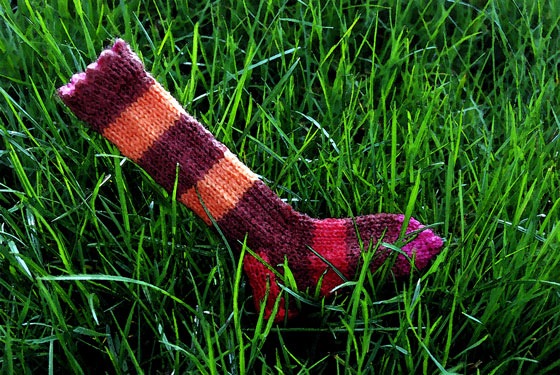 my wee tiny soccer sock on green grass before knitting exchange